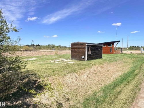 Two distinct structures featuring wood-finish siding and modern architectural elements, set on a broad lot with natural landscaping and open sky - 50 Ave. 52 St., Rural Westlock County, AB 