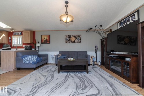 Open-concept living area featuring wood-finish flooring and a central ceiling light fixture - 143 48 3400 Street W, Stony Plain, AB 