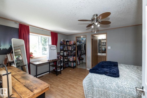 Room featuring wood-finish flooring, a ceiling fan with integrated lighting, and a window with a deep sill - 143 48 3400 Street W, Stony Plain, AB 