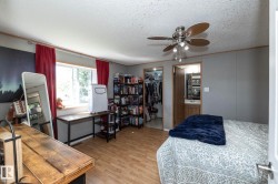 Room featuring wood-finish flooring, a ceiling fan with integrated lighting, and a window with a deep sill - 