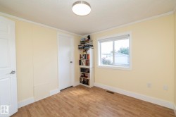 Bedroom featuring wood-finish flooring, a single window, and a flush-mount ceiling light fixture - 