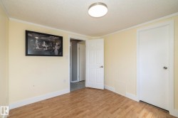 Room featuring wood-finish flooring, light-colored walls, white trim, and a flush-mount ceiling light fixture - 