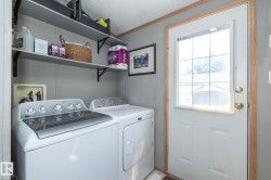 Utility area featuring two floating shelves, a paneled door with glass insert, and brass-finish hardware - 
