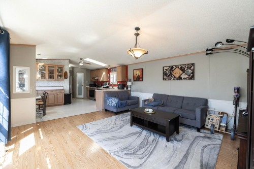 Open-concept living area featuring wood-finish flooring and a central ceiling light fixture - 143 48 3400 Street W, Stony Plain, AB 