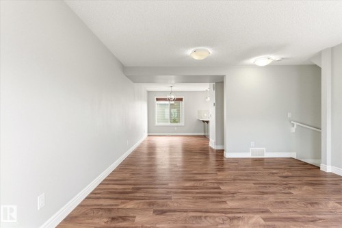 Spacious room featuring wood-finish flooring, light grey wall paint, and white baseboards - 47 330 Bulyea Road, Edmonton, AB - Indoor Photo Showing Other Room