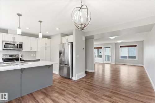 Bright kitchen with a spacious island featuring a white countertop and gray cabinetry - 47 330 Bulyea Road, Edmonton, AB - Indoor Photo Showing Kitchen With Stainless Steel Kitchen With Upgraded Kitchen