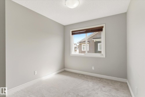 Neutral wall paint, light-colored carpet, and a window with blinds - 47 330 Bulyea Road, Edmonton, AB - Indoor Photo Showing Other Room