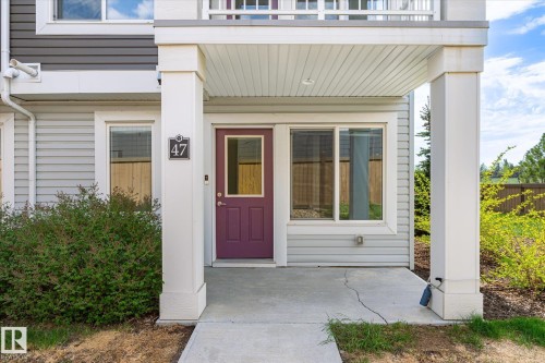 Entryway featuring a covered porch, purple paneled door with glass insert, and side-lite window - 47 330 Bulyea Road, Edmonton, AB - Outdoor With Balcony With Exterior