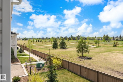 Expansive green space featuring mature trees and a walking path bordered by a wood privacy fence - 47 330 Bulyea Road, Edmonton, AB - Outdoor With View