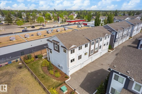 Modern townhouse exterior featuring light-colored siding, a dark roof, and multiple windows - 47 330 Bulyea Road, Edmonton, AB - Outdoor