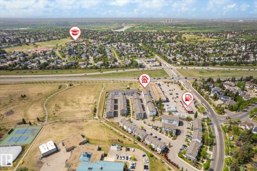 Aerial perspective of a developed neighborhood featuring residential buildings, commercial establishments, and a major roadway - 47 330 Bulyea Road, Edmonton, AB - Outdoor With View