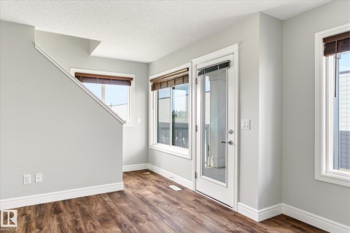 Wood-finish flooring throughout, complemented by light gray walls and white trim - 47 330 Bulyea Road, Edmonton, AB - Indoor Photo Showing Other Room