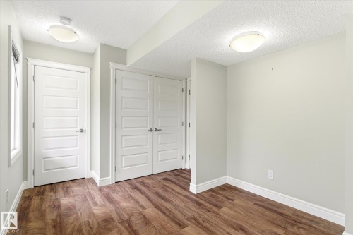 Interior room featuring wood-finish flooring, white baseboards, and light gray walls - 47 330 Bulyea Road, Edmonton, AB - Indoor Photo Showing Other Room