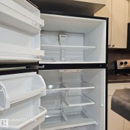 Top-freezer refrigerator featuring multiple interior shelves and door storage - 