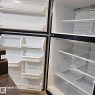 Top-freezer refrigerator featuring multiple door bins, adjustable shelving, clear crisper drawers, and a white interior finish - 