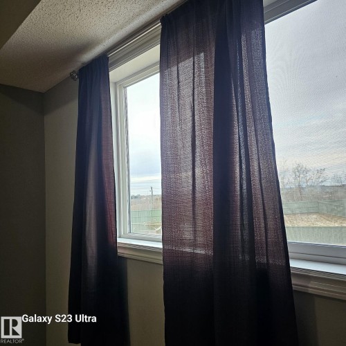 Window with white trim and dark fabric curtains - 99 13825 155 Avenue, Edmonton, AB 