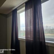 Window with white trim and dark fabric curtains - 