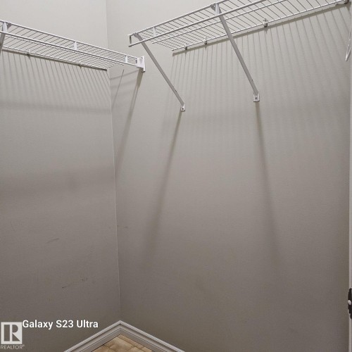 Walk-in closet featuring light gray walls, white wire shelving, and trim - 99 13825 155 Avenue, Edmonton, AB 