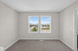 Room featuring two windows, neutral wall color, textured ceiling, grey carpeting, and white baseboards - 