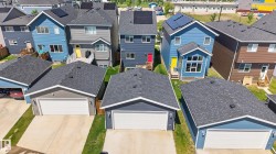 Aerial perspective showcasing a collection of modern detached homes with asphalt shingle roofs - 