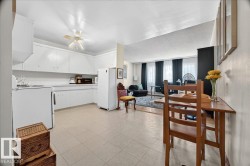 Kitchen featuring white cabinetry, light-toned tile flooring, and a ceiling fan - 