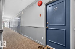 Hallway with patterned carpet flooring, two-tone wall paneling, crown molding, and recessed lighting - 