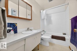 Bathroom featuring an integrated sink, laminate countertop, and wood-framed mirrored medicine cabinet - 