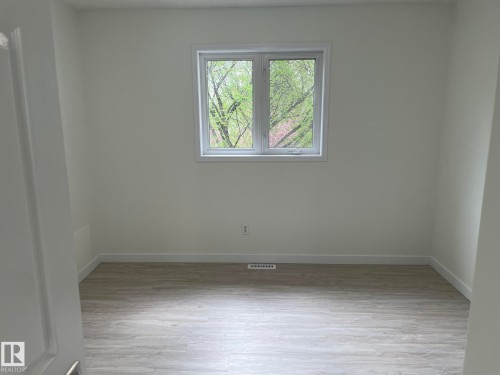 Room featuring light wood-finish flooring, white walls, and a casement window with white trim - 2 1295 Carter Crest Road, Edmonton, AB - Indoor Photo Showing Other Room