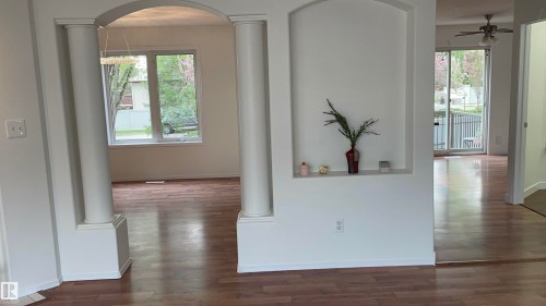 Interior architectural archways framing wood-finish flooring - 2 1295 Carter Crest Road, Edmonton, AB - Indoor Photo Showing Other Room