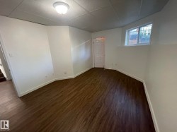 Room with wood-finish flooring, white walls, and a recessed window - 