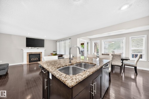 Kitchen island with dual stainless steel sinks and a stone-finish countertop - 3433 Goodridge Link Link, Edmonton, AB 