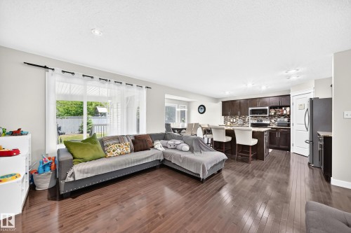 Open-concept living area with dark wood-finish flooring - 3433 Goodridge Link Link, Edmonton, AB 