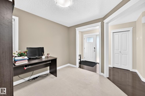 Neutral-toned room featuring a light-colored carpet, white trim, and a window with a white frame - 3433 Goodridge Link Link, Edmonton, AB 