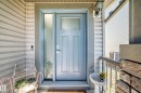 Entryway featuring a panel door with an upper window, a full-length sidelight, and an overhead porch light - 3433 Goodridge Link Link, Edmonton, AB 