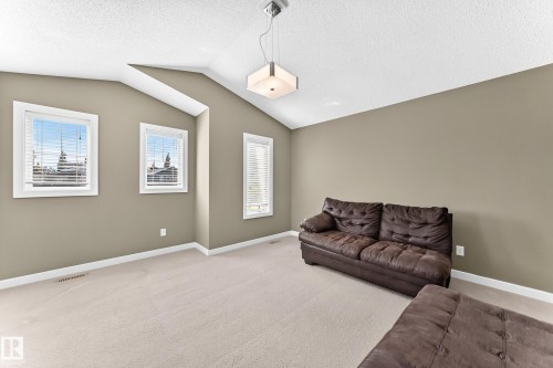 Carpeted room with vaulted ceilings and neutral-toned walls - 3433 Goodridge Link Link, Edmonton, AB 