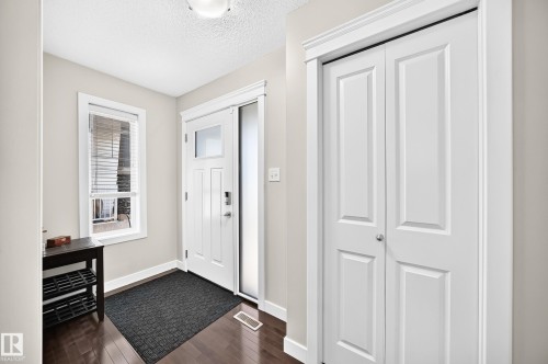 Entryway featuring wood-finish flooring and a white paneled door with glass inserts - 3433 Goodridge Link Link, Edmonton, AB 