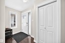 Entryway featuring wood-finish flooring and a white paneled door with glass inserts - 3433 Goodridge Link Link, Edmonton, AB 