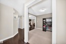 Entryway featuring dark wood-finish flooring, light neutral wall tones, and white trim - 3433 Goodridge Link Link, Edmonton, AB 