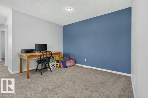 Room with neutral gray walls and a single accent wall in a deep blue hue - 2116 Maple Road, Edmonton, AB 