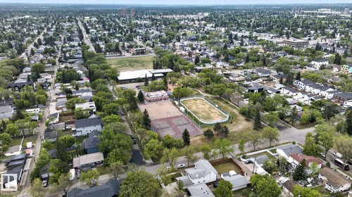 Expansive aerial showcasing a residential area with mature tree-lined streets, a public park, tennis courts, and a sports field - 9821 153 Street, Edmonton, AB - Outdoor With View