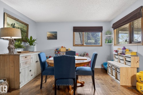 Hardwood flooring extends throughout this room, complemented by light gray wall paint - 9821 153 Street, Edmonton, AB - Indoor Photo Showing Dining Room
