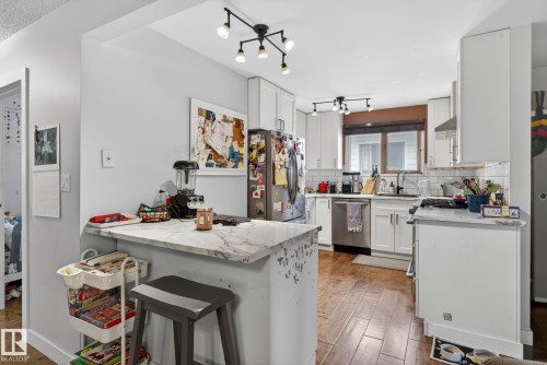 Kitchen featuring white shaker cabinetry, stainless steel appliances, and wood-finish flooring - 9821 153 Street, Edmonton, AB - Indoor Photo Showing Kitchen With Upgraded Kitchen