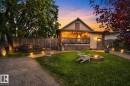 Rear exterior featuring a raised deck, a brick fire pit, and a grass lawn - 9821 153 Street, Edmonton, AB  - Outdoor With Deck Patio Veranda 