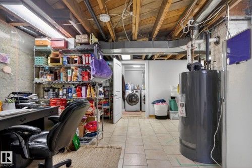 Unfinished basement area featuring exposed ceiling joists, concrete block walls, and tile flooring - 9821 153 Street, Edmonton, AB - Indoor Photo Showing Basement