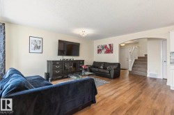 Open-concept living space with wood-finish flooring - 