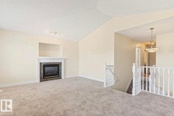 Living area with a fireplace featuring a dark tile surround and white mantel - 