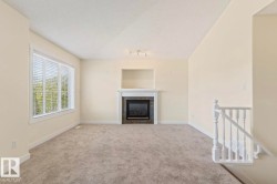Living area featuring a fireplace with a slate surround and white mantel, a built-in recess above the mantel, and track lighting - 