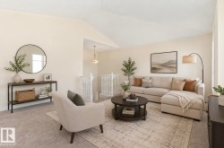 Spacious living area featuring neutral carpeting, a vaulted ceiling, and an open-concept design with a visible staircase balustrade - 