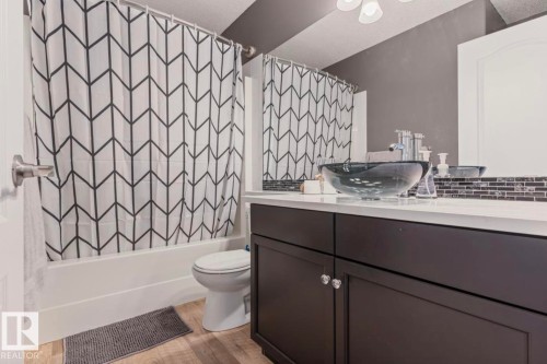 Vanity with a black vessel sink, white countertop, and dark wood-finish cabinetry - 1007 Macewan Cl, Edmonton, AB 