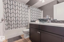 Vanity with a black vessel sink, white countertop, and dark wood-finish cabinetry - 